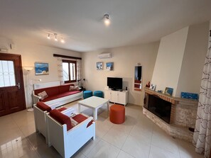 Relax in this stylish living room with a sofa, coffee table, flat-screen TV, and fireplace.
