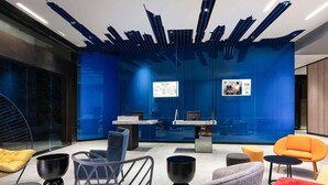 Egy modern belső tér, recepciós pulttal, ülősarokkal és üvegfalakkal.