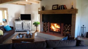 A living room with a fireplace, a television, and a sofa.