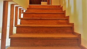 A wooden staircase with a handrail, leading to a door at the top.