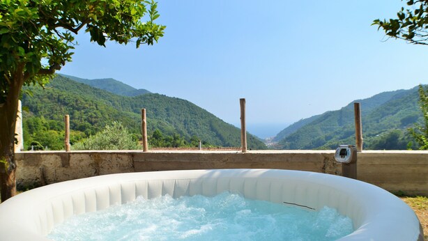 Un jacuzzi al aire libre con vistas a un paisaje montañoso.