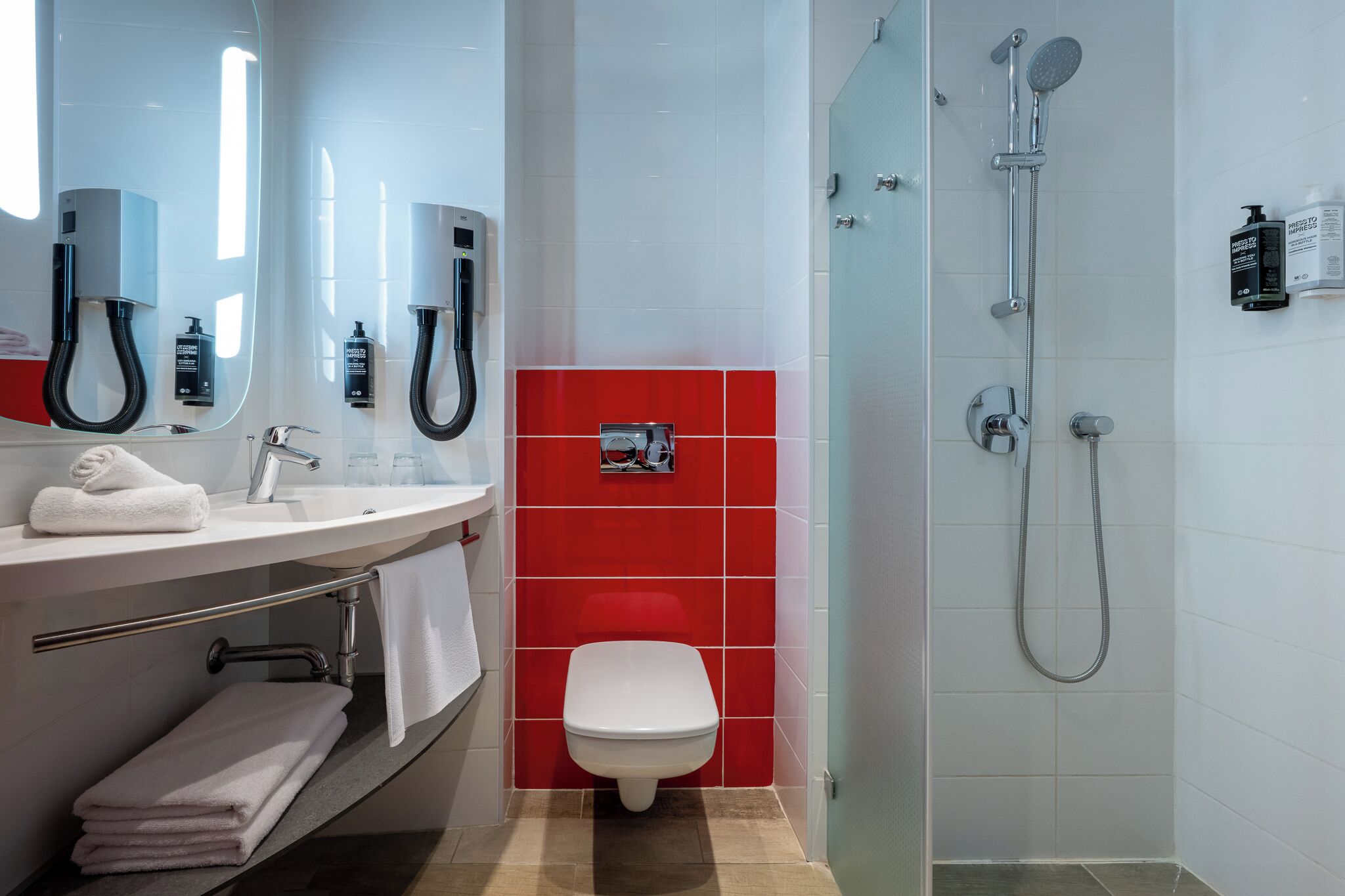 A modern bathroom with a glass-enclosed shower, a white toilet, and a vanity with a towel rack.