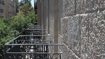 A staircase with ornate metal railings leading up to a building with stone walls.