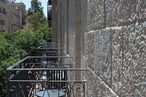 A staircase with ornate metal railings leading up to a building with stone walls.