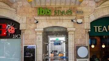 Fachada de una tienda con un letrero que dice 'ibis STYLES' y una entrada visible.