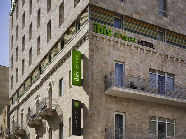 A hotel with a stone facade, multiple balconies with wrought iron railings, and signage indicating it is part of the ibis Styles Hotel chain. - ibis Styles Jerusalem City Center - An AccorHotels Brand (Jerusalem)