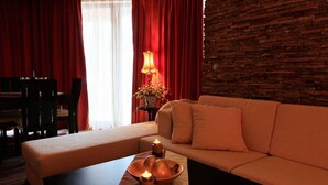 Ein Hotelzimmer mit einer Couch, einem Esstisch und einer Lampe.