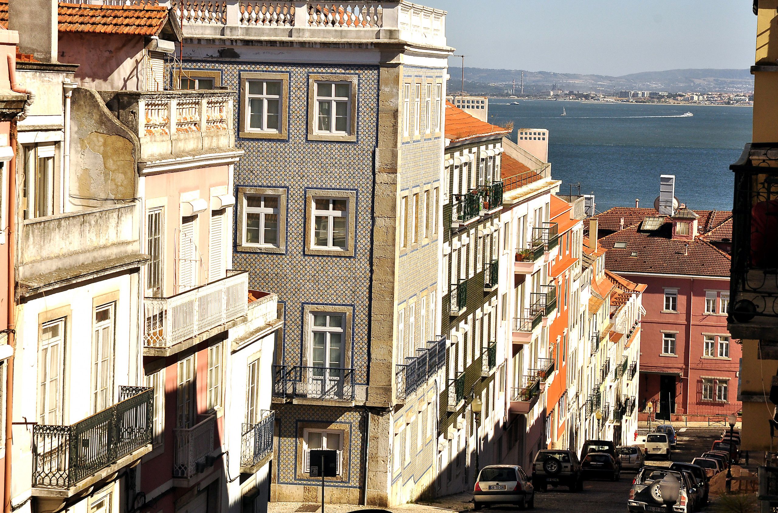 A row of buildings with balconies overlooking a body of water.