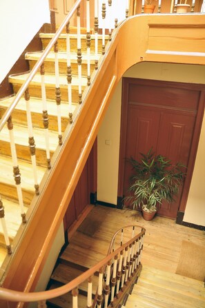 Eine Holztreppe mit Handlauf, die zu einer Zwischenebene führt.