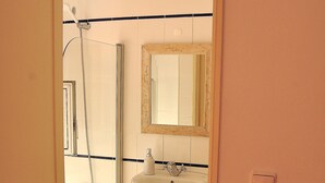 A bathroom with a shower, sink, and mirror. - Comfortable and stylish apartment, fully equipped, in Lapa in Lisbon (Lisboa ciudad)