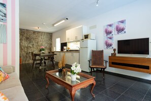 A modern living room with a sofa, coffee table, and a TV mounted on the wall.