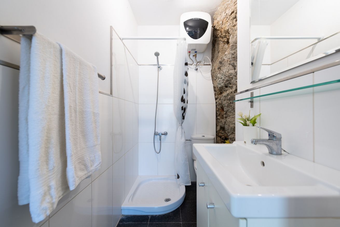 A bathroom with a shower, toilet, and sink.