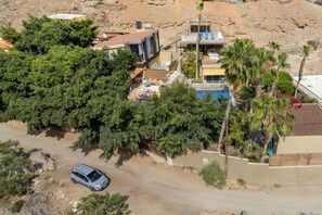 Una zona residencial con una casa moderna, una piscina y un automóvil estacionado.