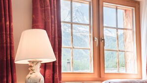 Une pièce avec une grande fenêtre, une lampe et une vue sur une montagne.