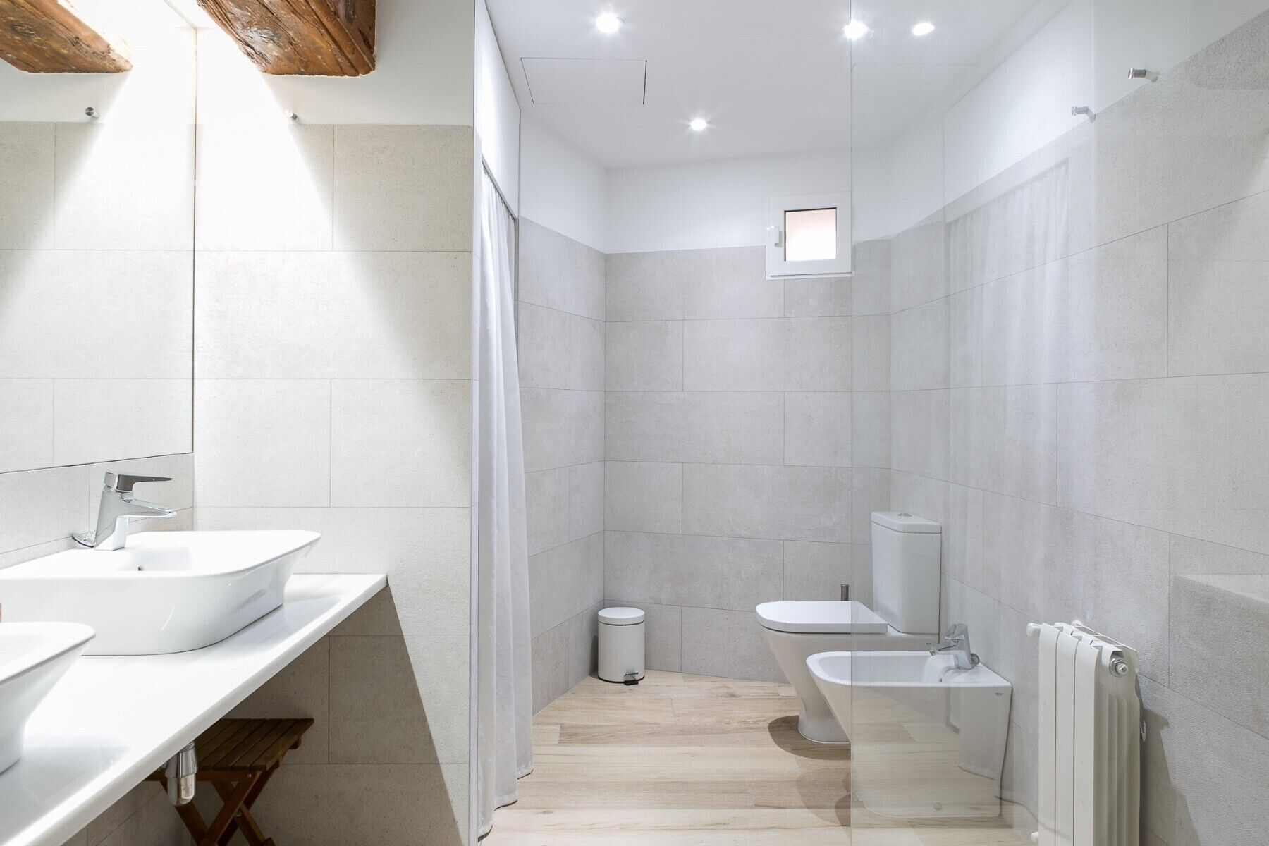 A modern bathroom with a white sink, a toilet, and a bidet.