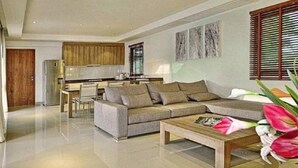 Una sala de estar moderna con un sofá, una mesa de centro y un comedor con una silla y una mesa.