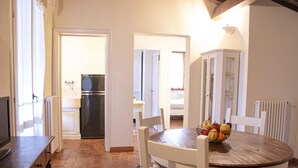 Una cocina con mesa, sillas, refrigerador y un armario.