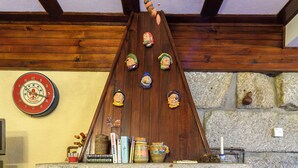 A stone fireplace with a wooden mantel, surrounded by stone walls and wooden beams.