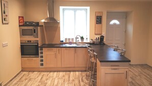 Una cocina moderna con una isla central, electrodomésticos de acero inoxidable y un ventanal que proporciona luz natural.