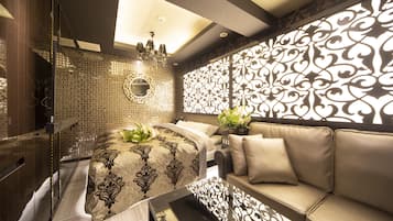 A modern bathroom with a freestanding bathtub, a vanity with a mirror, and a decorative wall panel.