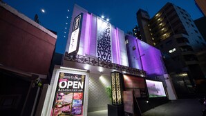 A hotel with a prominent 'OPEN' sign, a large illuminated signboard, and a modern facade with geometric patterns. - HOTEL G-Style - Adults Only (Tokyo)