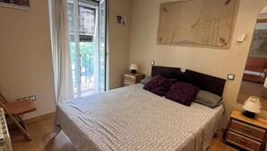 A bedroom with a bed, bedside tables, a window with curtains, a radiator, and a wall-mounted artwork. - 2 Bedroom Apartament for rent next Atocha St. (Madrid)