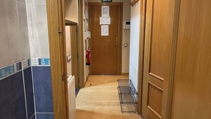 A hallway with a wooden door labeled "SALIDA" and a fire extinguisher on the wall. - 2 Bedroom Apartament for rent next Atocha St. (Madrid)