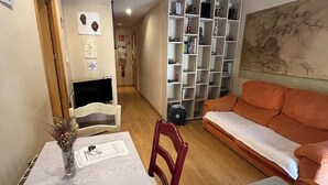 A cozy living room with a dining table, chairs, a sofa, and a bookshelf. - 2 Bedroom Apartament for rent next Atocha St. (Madrid)
