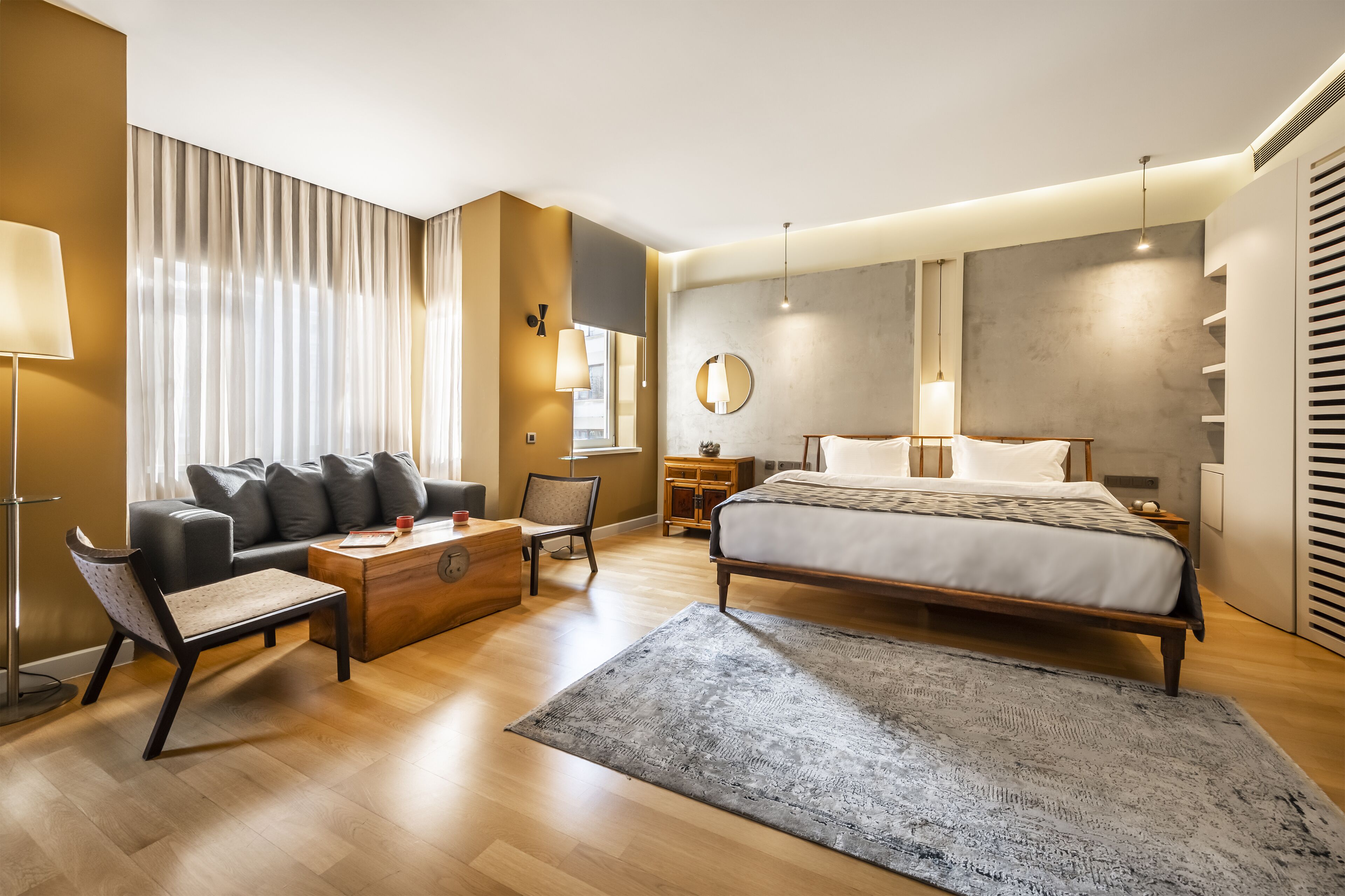 Un dormitorio moderno con una cama grande, un sofá, una mesa de centro y un escritorio.