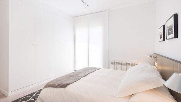 A modern bedroom with a large bed, a wardrobe, and a radiator. - Nice duplex in the center of Terrassa (Barcelona) (Terrassa)