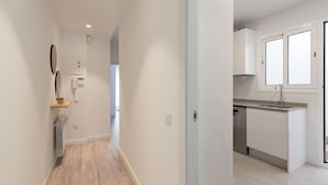 A modern kitchen with white cabinets, a stainless steel dishwasher, and a window above the sink. - Nice duplex in the center of Terrassa (Barcelona) (Terrassa)