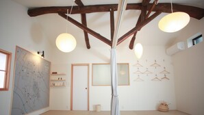 Una habitación amplia con techo alto, vigas de madera a la vista y un gran mapa en la pared.