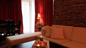 Ein gemütliches Zimmer mit einer Couch, einem kleinen Tisch mit Kerzen und einer Lampe.