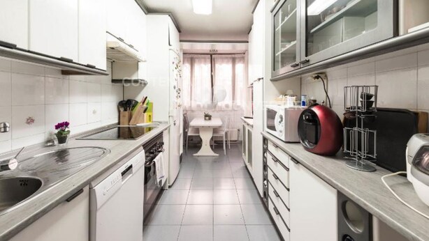 A compact kitchen with white cabinets, a microwave, a coffee maker, and a sink.