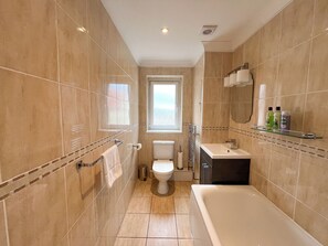 A modern bathroom with a bathtub, toilet, and sink. - Boutique Apartment on Royal Mile - Sleeps 3 (Edinburgh)