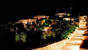 A nighttime view of a hillside with modern buildings, stone steps, and illuminated windows. - Villa  'Miami' in Villa Paradise Boutique Villas Hotel- Plaka beach (Naxos)