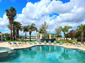A swimming pool with lounge chairs, a small building, palm trees, and a clear sky. - 2 POOLS, FOOTBALL PITCH, TENNIS COURT, CINEMA ROOM, GYM, BAR, PRIVATE CHEF (Poceirão)