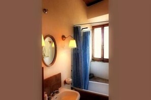 Tina con regadera, secadora de cabello, bidet, toallas 