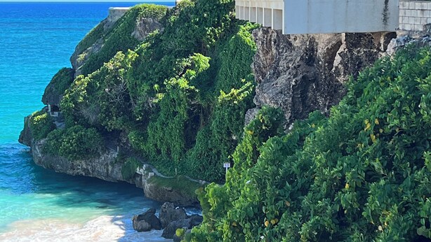 A coastal hotel with a view of the ocean and a beach.