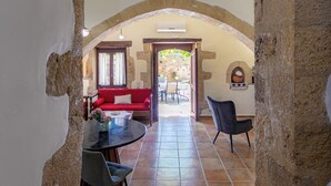 A spacious interior with a high ceiling, stone walls, and a red sofa in the background. - Private Pool★Stone Villa★ BBQ & Wifi★ Jacuzzi (Astratigos)