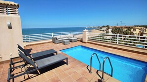 A rooftop pool with a view of the sea, a white railing, and a sofa. - Sunrise 01 by homeprive (Denia)