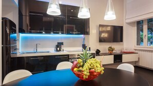 A modern kitchen with a black countertop, white cabinets, and a fruit bowl on the table. - New duplex apts in VATICAN - M + I (Roma)