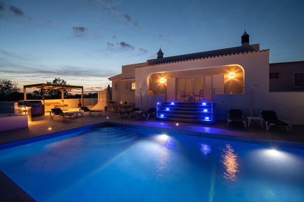 A swimming pool with lounge chairs and a covered seating area with steps leading up to it. - Family Villa Poco Parido/Carvoeiro - Spacious 5 bedrooms - Private Pool (Carvoeiro)