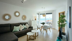Un salon moderne avec un canapé, une table basse et un coin repas.