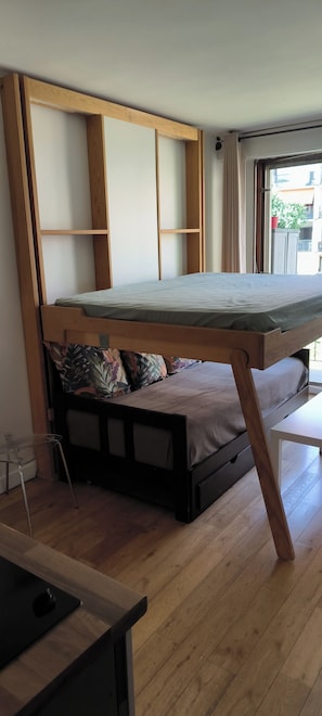 A compact room with a bunk bed, a small table, and a chair.