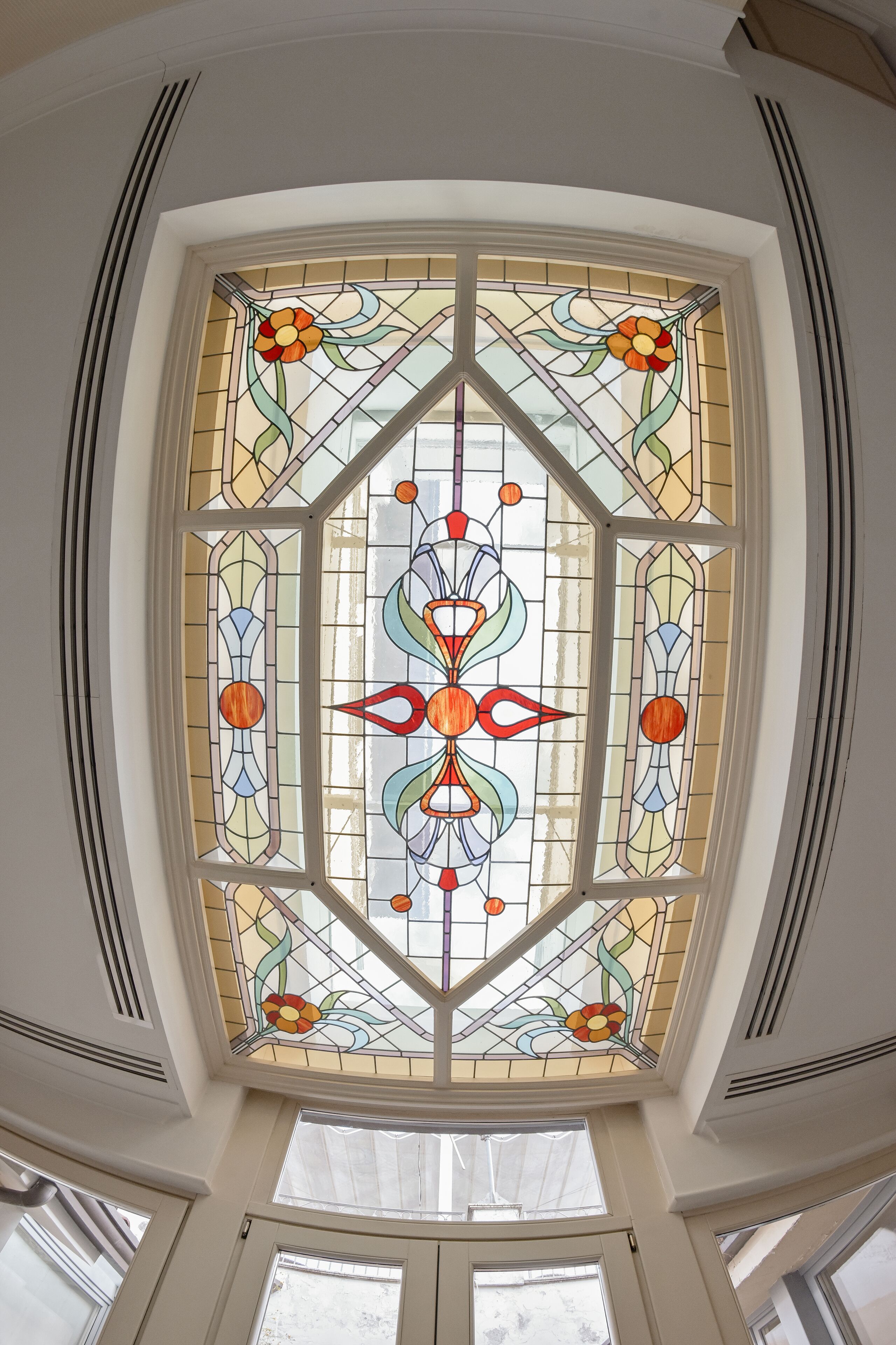 A stained glass window with geometric floral patterns.