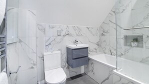 A modern bathroom with a toilet, sink, and shower. - 1 Bedroom City Centre Holiday home (York)