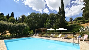 A swimming pool with lounge chairs and umbrellas, surrounded by greenery and trees. - Near Siena (6 km), in Chianti, swimming pool and terrace, Wi-fi, A / C (Villa parigini)