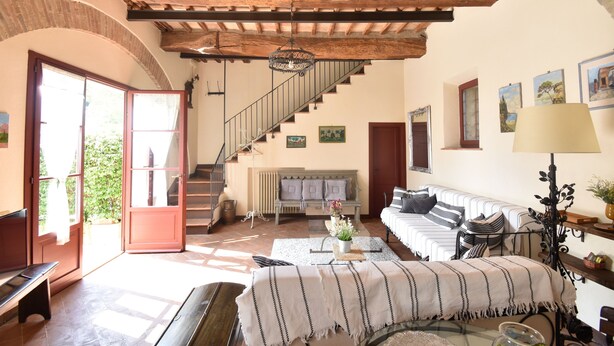 A spacious living area with a wooden ceiling, a staircase, a bench, a sofa, and a table with a vase of flowers. - Near Siena (6 km), in Chianti, swimming pool and terrace, Wi-fi, A / C (Villa parigini)