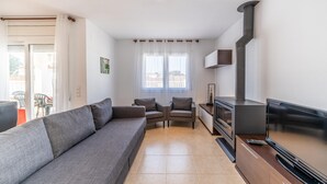 A modern living room with a grey sofa, two armchairs, a flat-screen TV, and a fireplace. - Olivia: Villa with private pool in L'Escala (L'Escala)